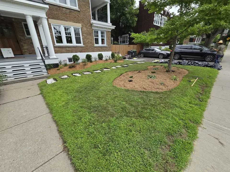 New mulched garden bed and stepping-stone path in a front lawn — after