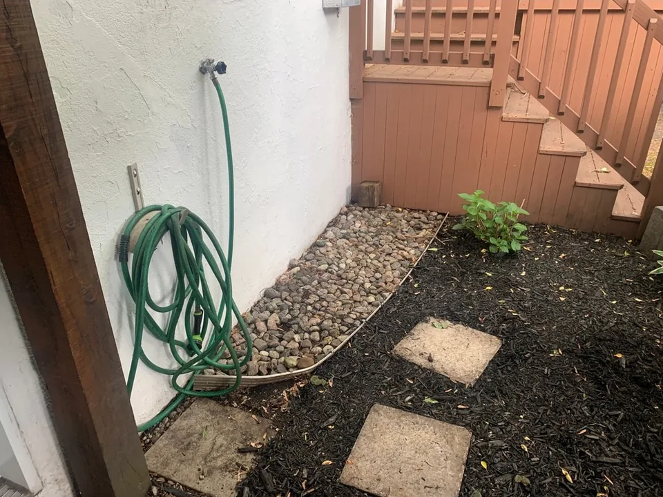 Side garden beside a wooden staircase — after