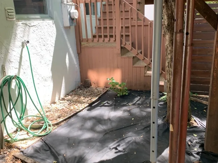 Side garden beside a wooden staircase — before